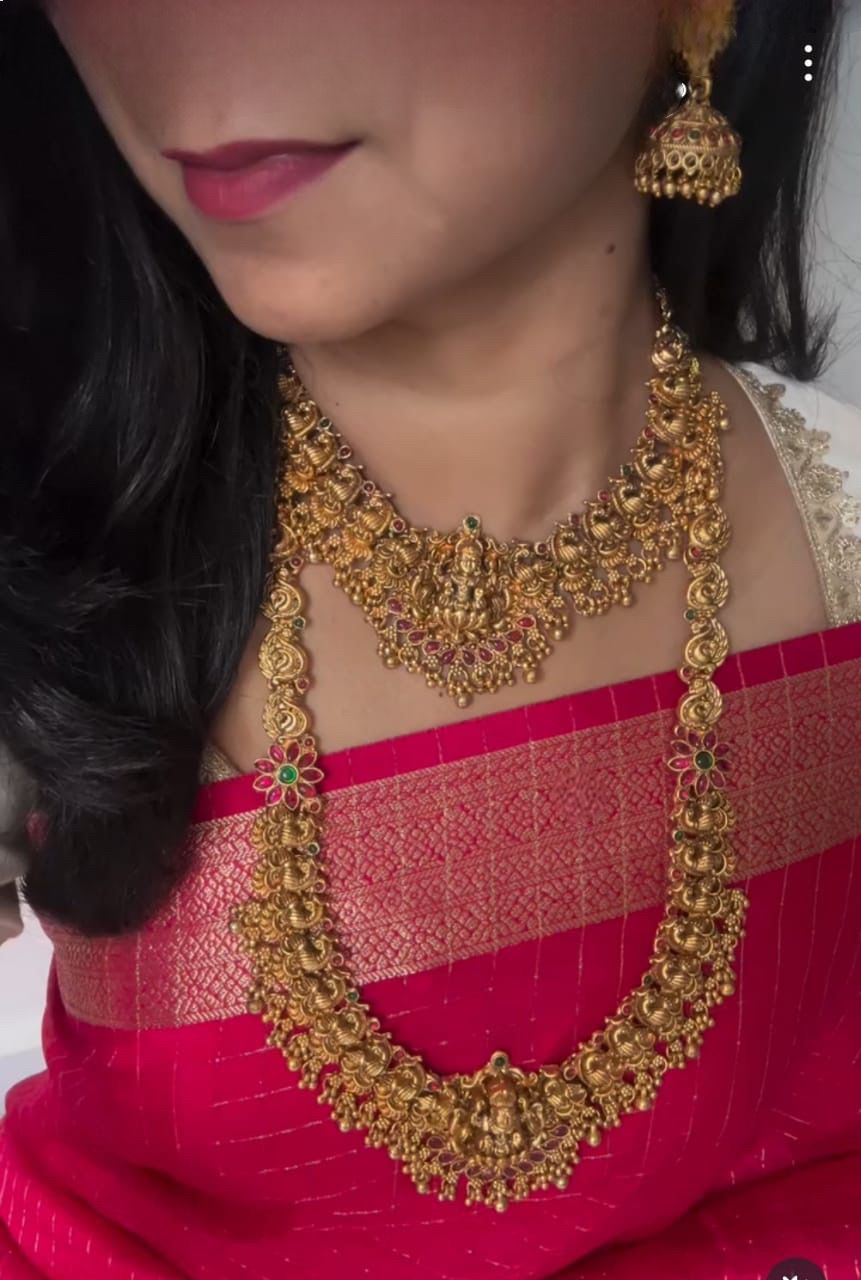 A TRADITIONAL INDIAN GOLD NECKLACE SET, INCLUDING A SHORTER NECKLACE AND A LONGER, ELOBORATE NECKLACE,ALONG WITH MATCHING EARRINGS